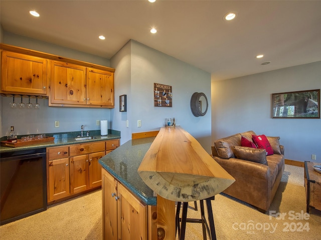 kitchen with dishwasher, light carpet, dark stone countertops, a kitchen breakfast bar, and sink