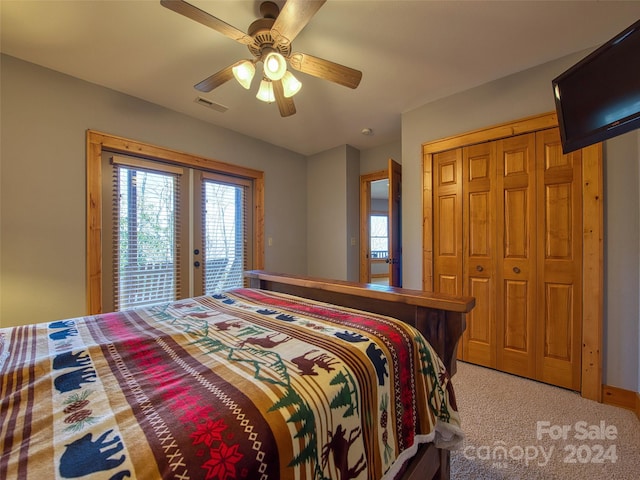 bedroom with a closet, ceiling fan, light colored carpet, access to outside, and french doors