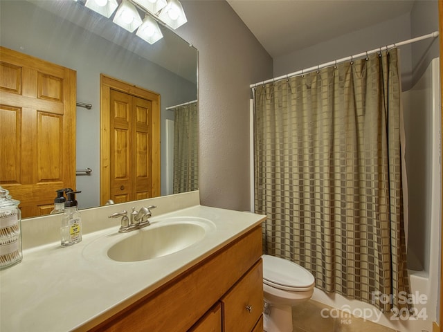 full bathroom with vanity with extensive cabinet space, tile floors, toilet, and shower / bath combo