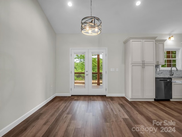 unfurnished dining area featuring sink, a notable chandelier, dark hardwood / wood-style flooring, and french doors