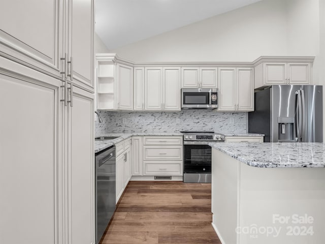 kitchen with sink, backsplash, white cabinets, and stainless steel appliances