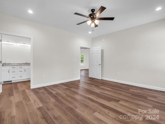 unfurnished bedroom featuring ceiling fan, sink, and hardwood / wood-style flooring