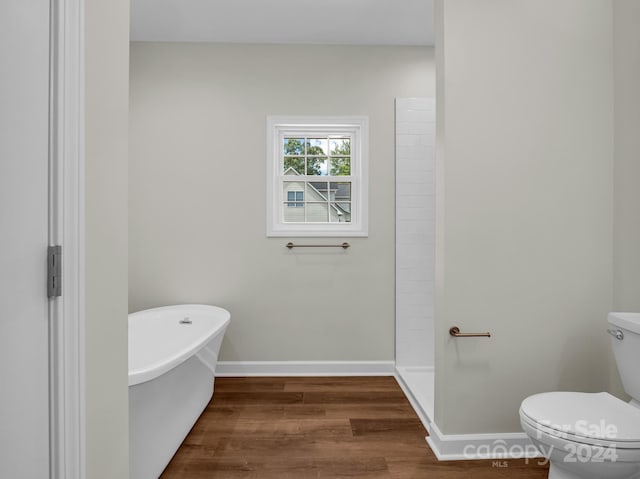 bathroom with wood-type flooring, toilet, and separate shower and tub