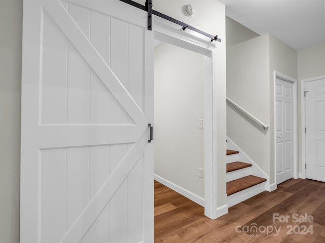 stairway featuring a barn door and hardwood / wood-style floors