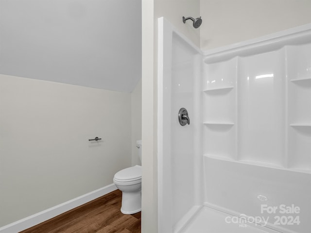 bathroom with hardwood / wood-style flooring, toilet, and walk in shower