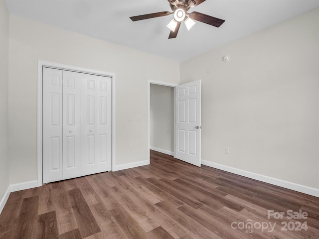 unfurnished bedroom with ceiling fan, a closet, and hardwood / wood-style floors