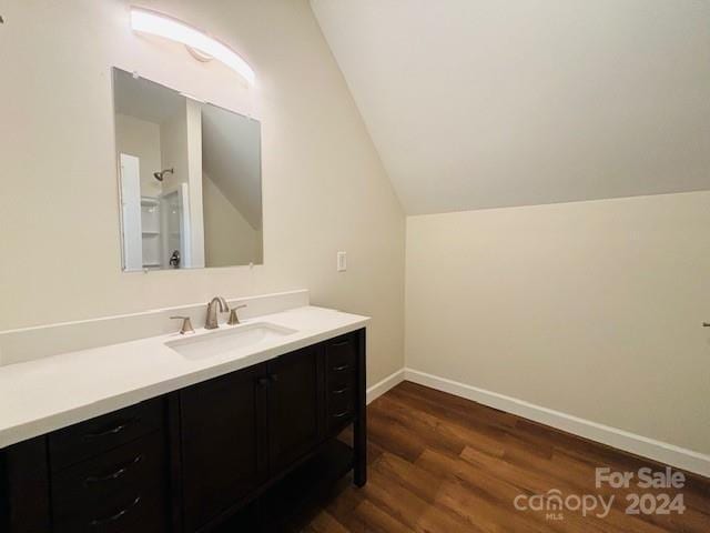 bathroom featuring vanity, vaulted ceiling, and hardwood / wood-style flooring