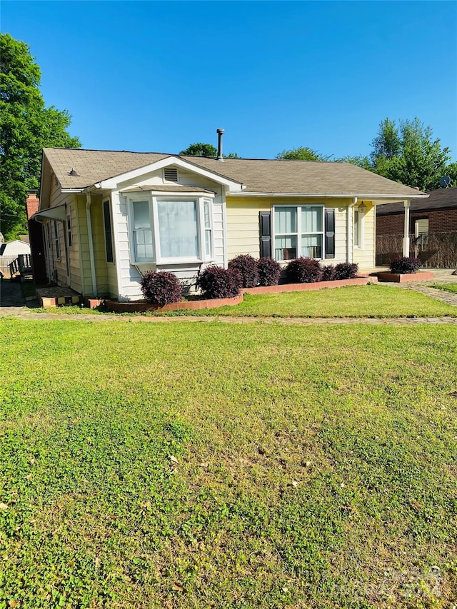 ranch-style home featuring a front lawn