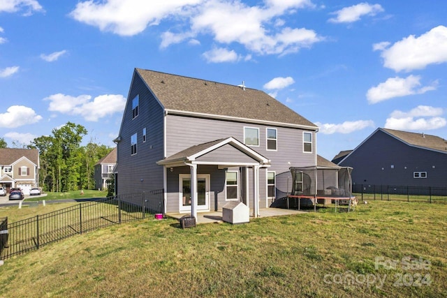 rear view of house featuring a trampoline, a yard, and a patio area