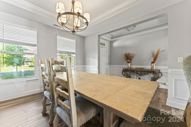 dining room featuring hardwood / wood-style flooring, crown molding, a chandelier, and a tray ceiling