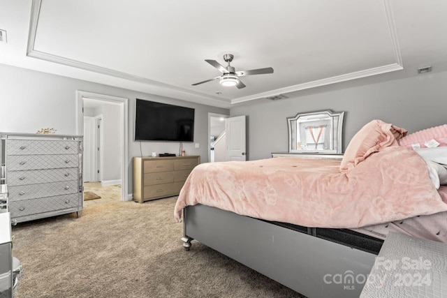 carpeted bedroom with a raised ceiling and ceiling fan