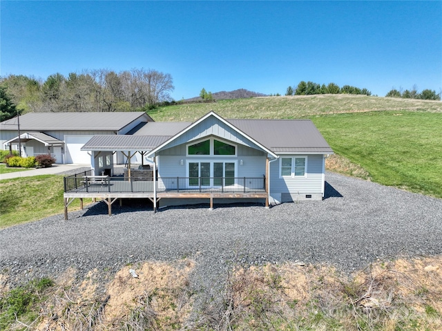 view of front of property with a front lawn, a wooden deck, and a garage