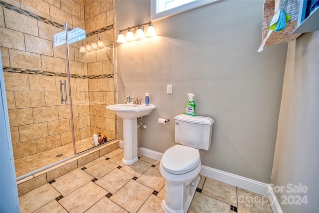 bathroom featuring sink, an enclosed shower, toilet, and tile flooring