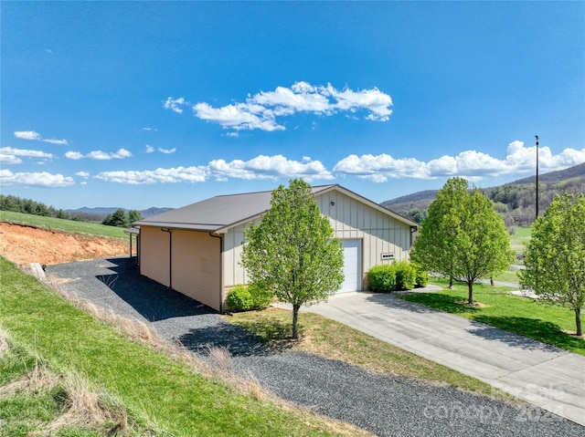 view of side of property with a mountain view and a garage