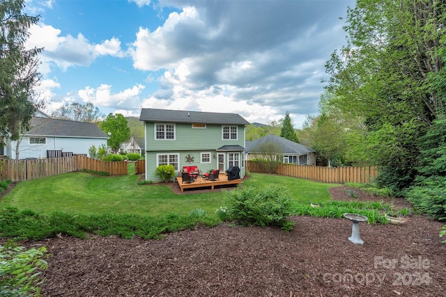 back of house featuring a wooden deck and a lawn