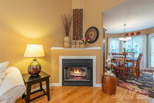 living room with hardwood / wood-style flooring and a notable chandelier