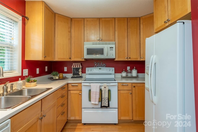 kitchen featuring white appliances, sink, and light wood-type flooring