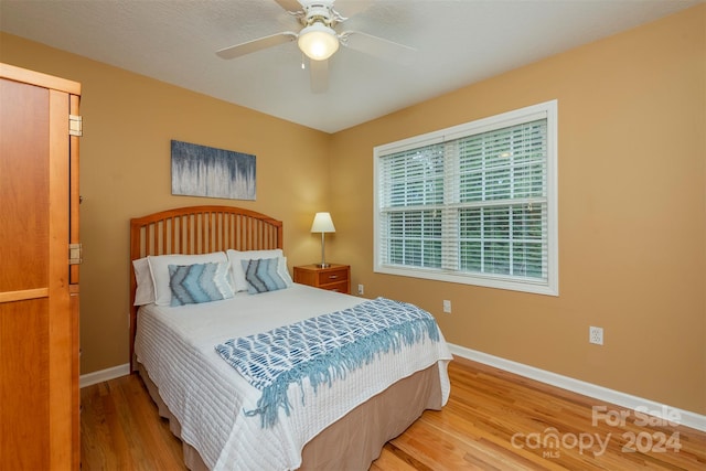 bedroom featuring wood-type flooring, ceiling fan, and a closet