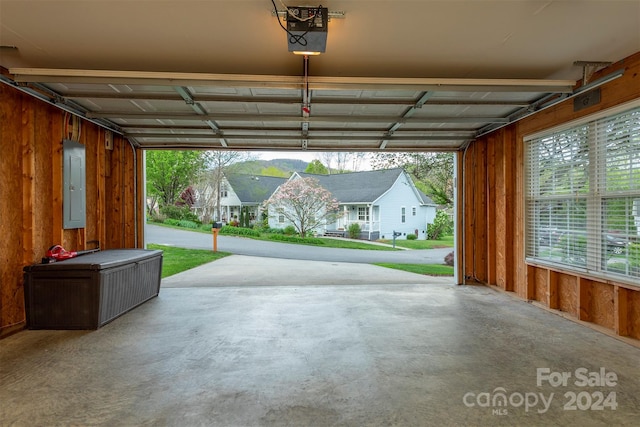 garage with wood walls and a garage door opener