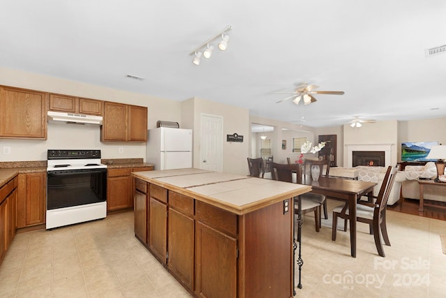 kitchen with white appliances, light tile flooring, rail lighting, tile countertops, and ceiling fan