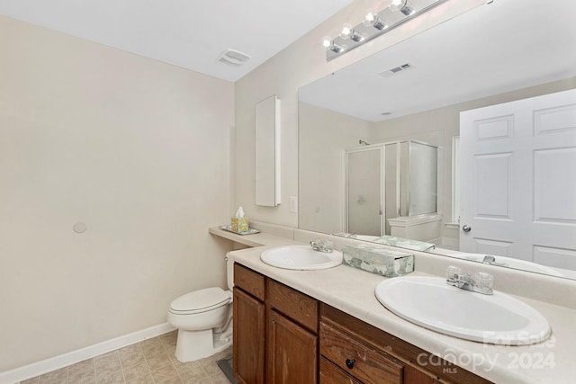 bathroom with tile flooring, double sink vanity, and toilet