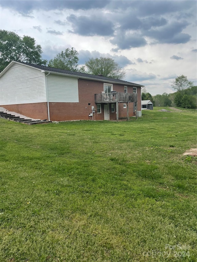 rear view of property with a wooden deck and a lawn