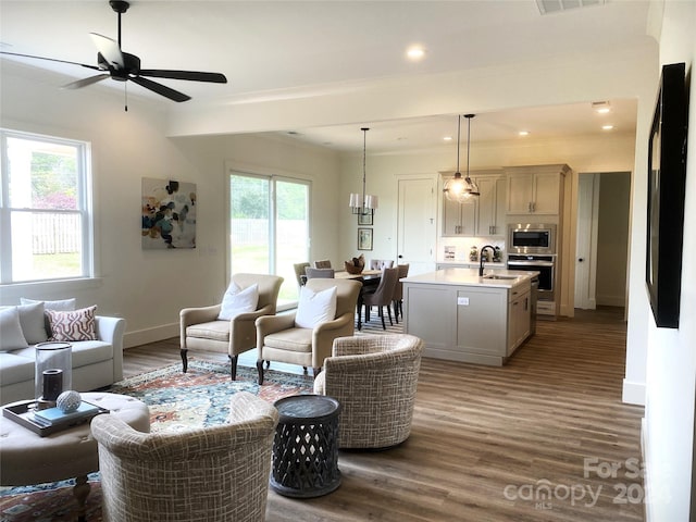 living room with crown molding, sink, ceiling fan, and dark hardwood / wood-style flooring