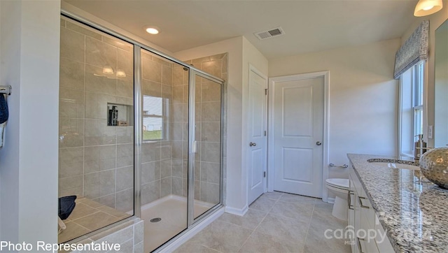 bathroom with an enclosed shower, vanity, toilet, and tile flooring