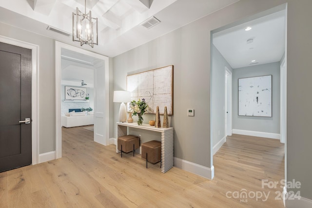 hall featuring a chandelier and light hardwood / wood-style floors