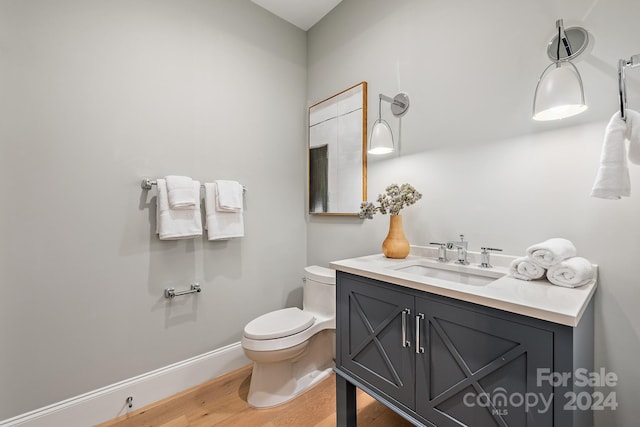 bathroom featuring toilet, hardwood / wood-style flooring, and vanity