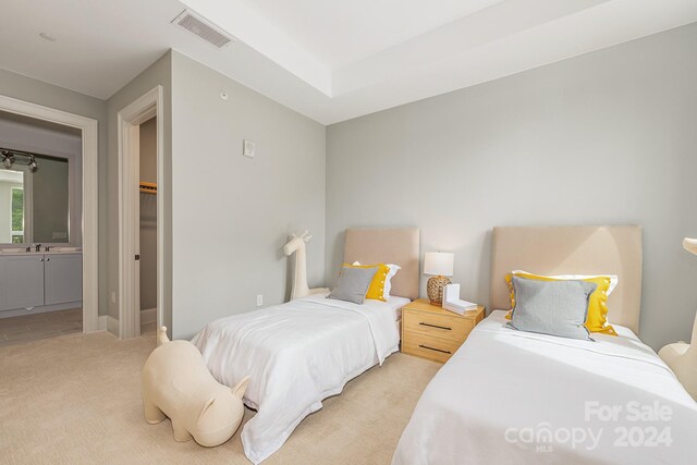 bedroom featuring ensuite bath and light carpet