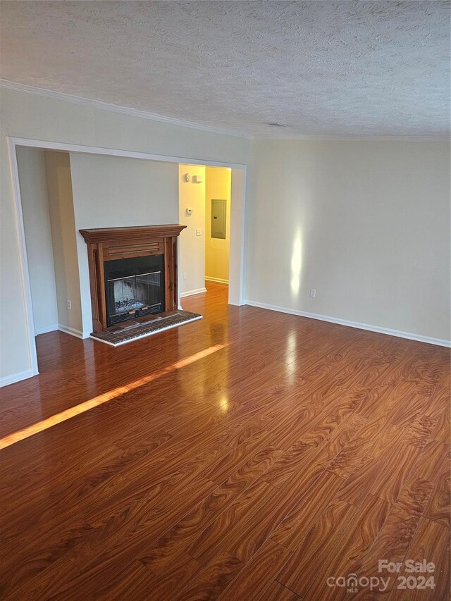 unfurnished living room featuring dark hardwood / wood-style floors and a textured ceiling