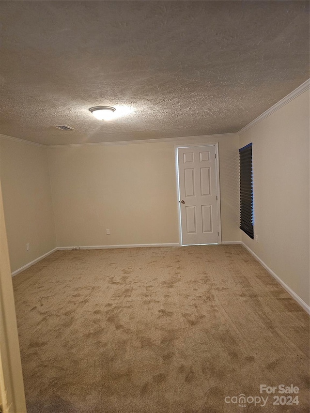 carpeted empty room featuring a textured ceiling