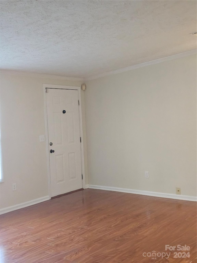 empty room featuring wood-type flooring and a textured ceiling