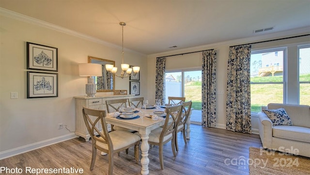 dining room with wood-type flooring, a notable chandelier, and ornamental molding