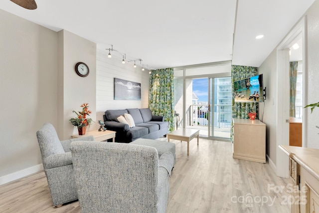 living room featuring light hardwood / wood-style flooring, floor to ceiling windows, and track lighting