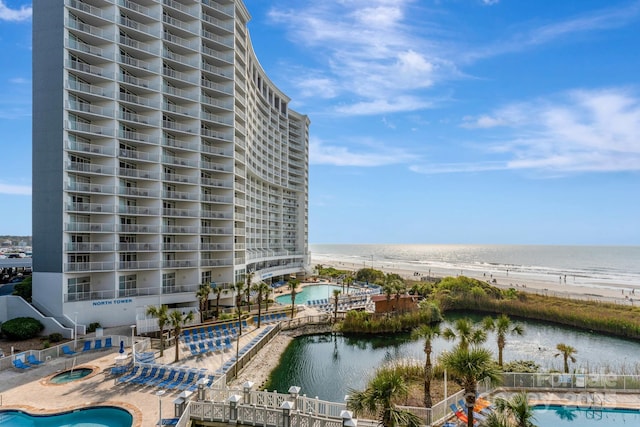 exterior space featuring a community pool, a beach view, and a water view