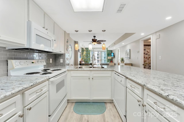 kitchen with sink, white appliances, backsplash, white cabinets, and light wood-type flooring