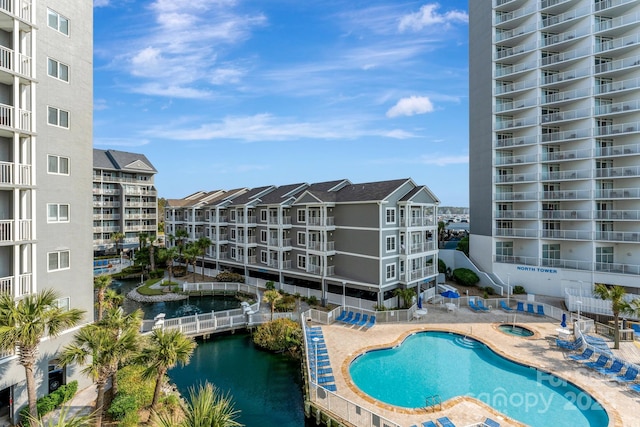 view of swimming pool featuring a water view and a patio