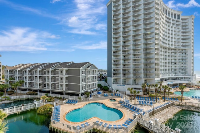 view of swimming pool featuring a water view and a patio area