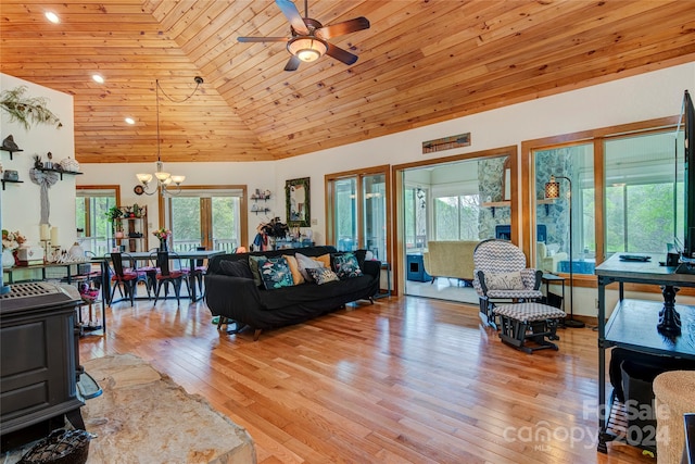 living room featuring wooden ceiling, a wood stove, light wood-type flooring, high vaulted ceiling, and ceiling fan with notable chandelier