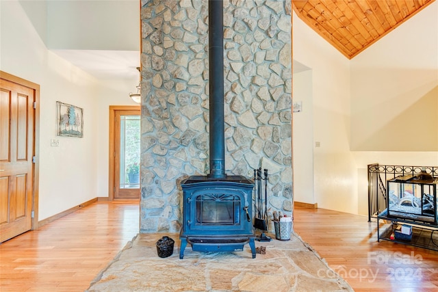 living room featuring high vaulted ceiling, hardwood / wood-style floors, a wood stove, and wooden ceiling