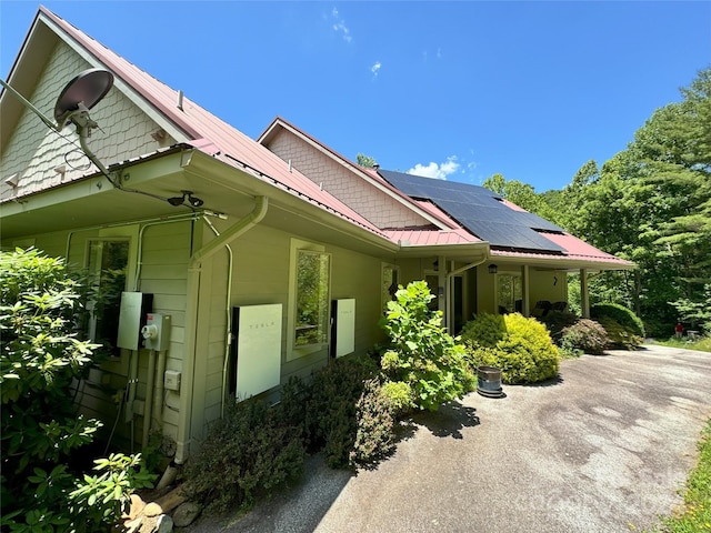 view of side of property featuring solar panels