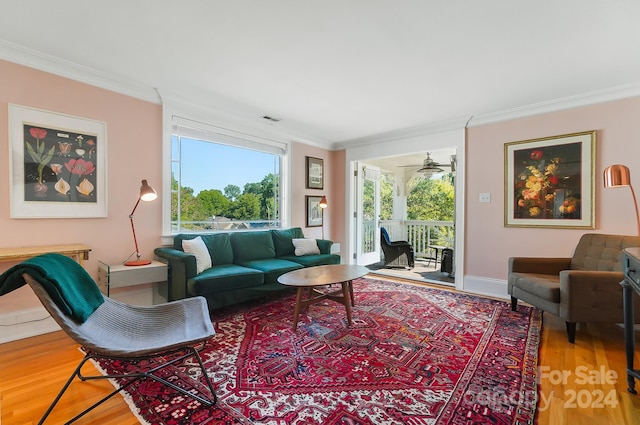 living room with hardwood / wood-style flooring, ornamental molding, and ceiling fan