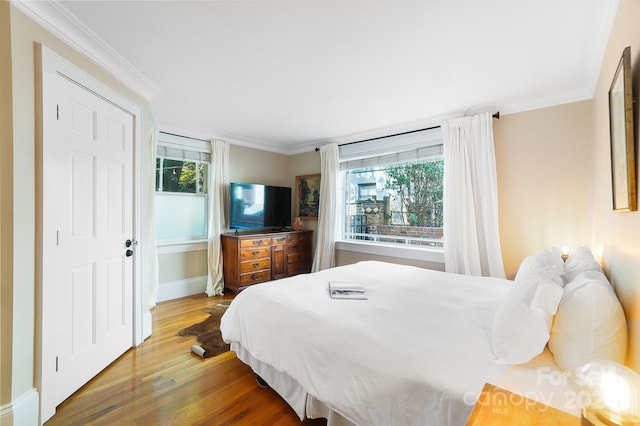 bedroom with ornamental molding and wood-type flooring