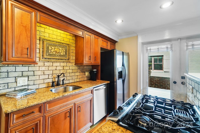 kitchen featuring appliances with stainless steel finishes, sink, and light stone countertops