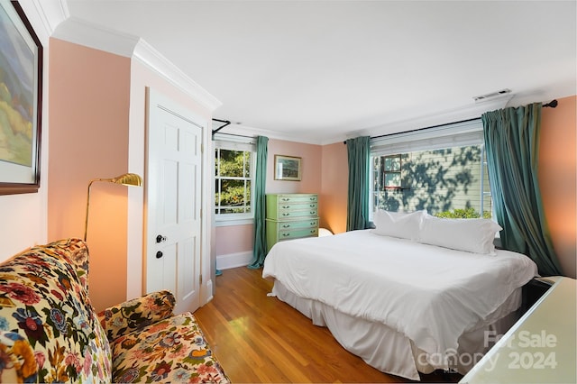 bedroom with light hardwood / wood-style flooring and ornamental molding