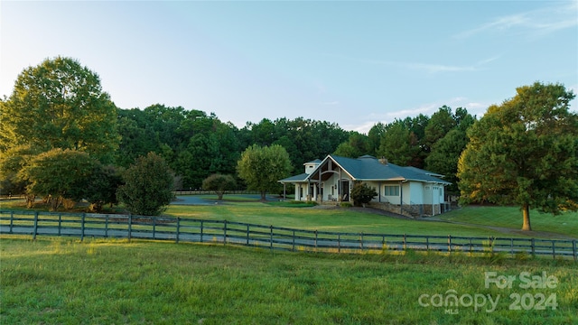 view of front of property featuring a front yard and a rural view