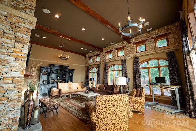 living room featuring a towering ceiling, a chandelier, beamed ceiling, and hardwood / wood-style flooring