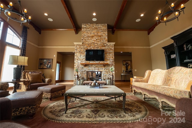 living room with a high ceiling, wood-type flooring, a fireplace, and beamed ceiling